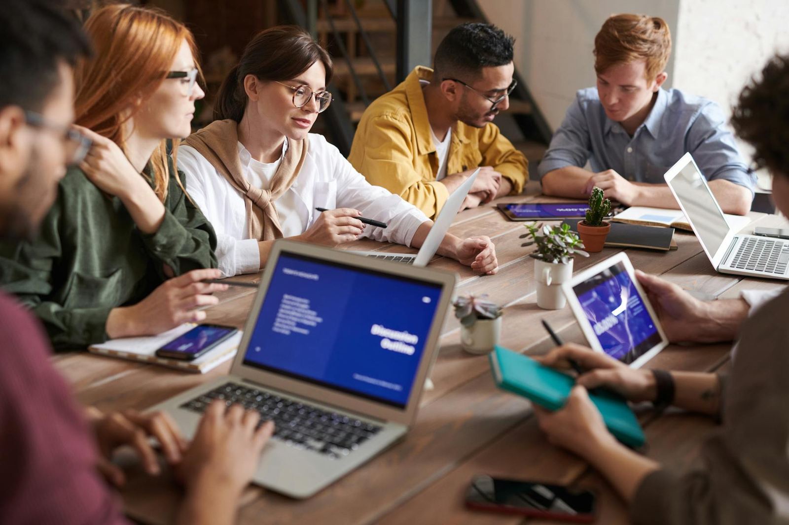 Diverse team meeting around laptops in a small business setting
